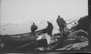 Image: Three men loading long boat